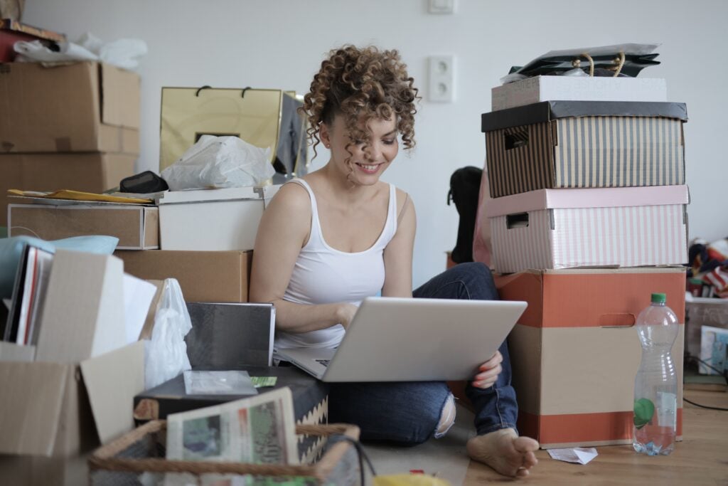 Lady in a messy room surrounded by boxes